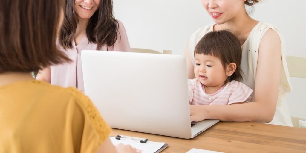 パソコンを見るママたちと赤ちゃん