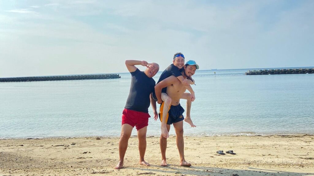 海で友人におんぶされる木村さんとピースをしている久保田さん