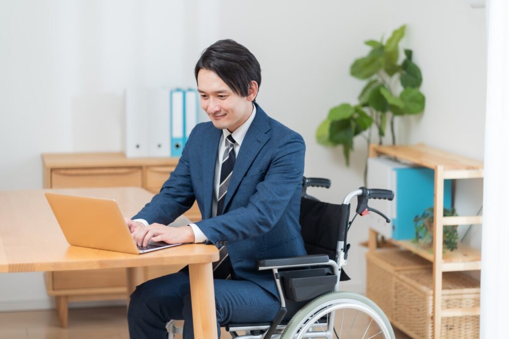 車椅子でパソコン作業をする男性