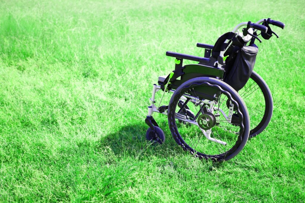 芝生の上に背を向けて止まっている車椅子