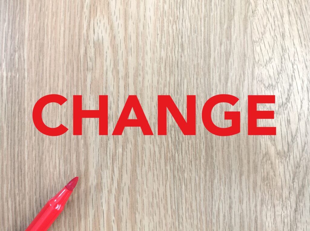 木目の背景に赤い字で「CHANGE」